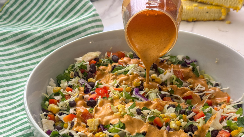 pouring dressing over salad