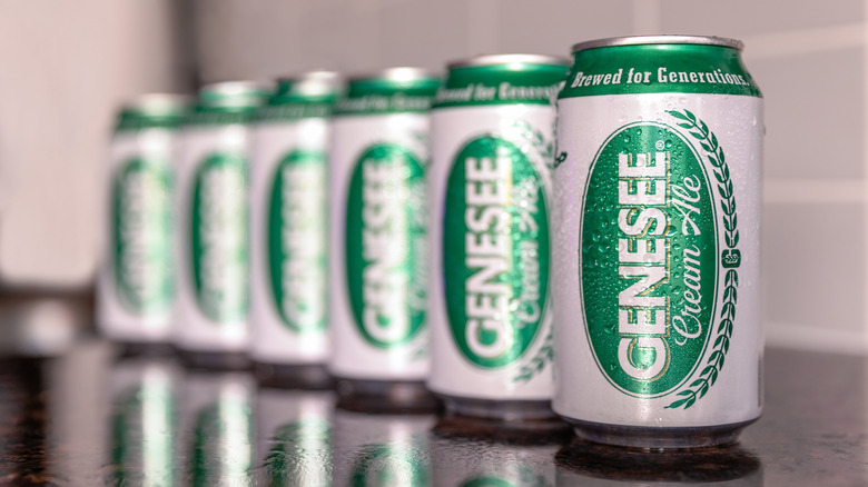 Cold refreshing cans of Genesee Brewery Cream Ale reflecting on a marble bar top.