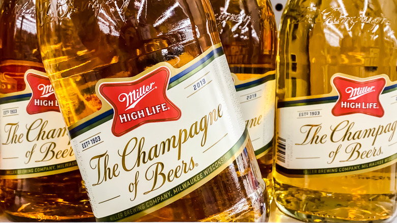 Close-up shot of the label denoting "The Champagne of Beers" on a bunch of Miller High Life pony bottles.