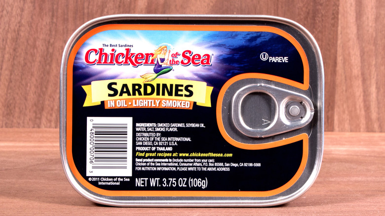 A can of chicken of the sea brand sardines packed in oil against the wood backdrop