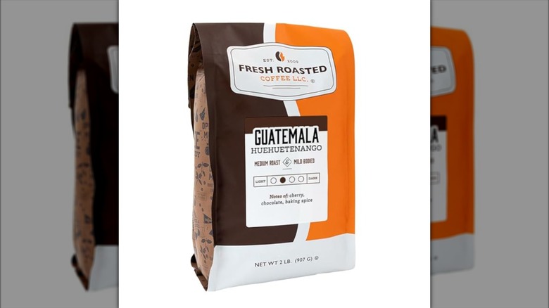 Brown and orange bag of Guatemalan Huehuetenango coffee isolated on white background