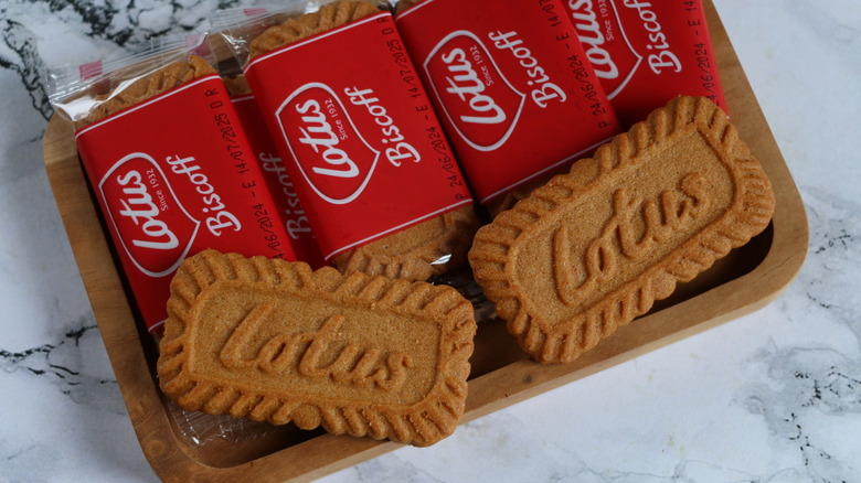 Overhead shot of several sleeves of Lotus Biscoff cookies stacked on a tray, with two cookies loose
