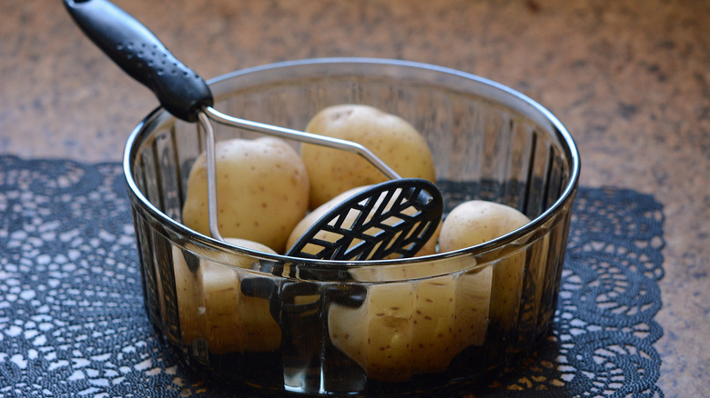 An old fashioned potato masher in a bowl