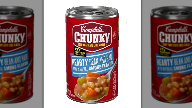 a can of Campbell's Chunky Hearty Bean and Ham soup against a white background