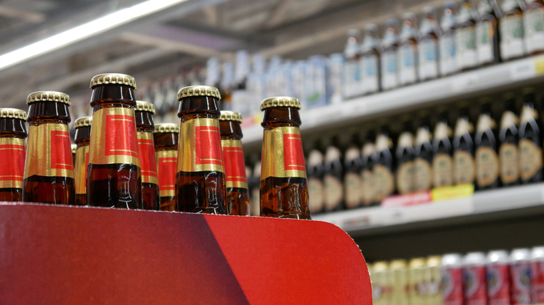 12-pack of beer bottles in foreground, other beers in background