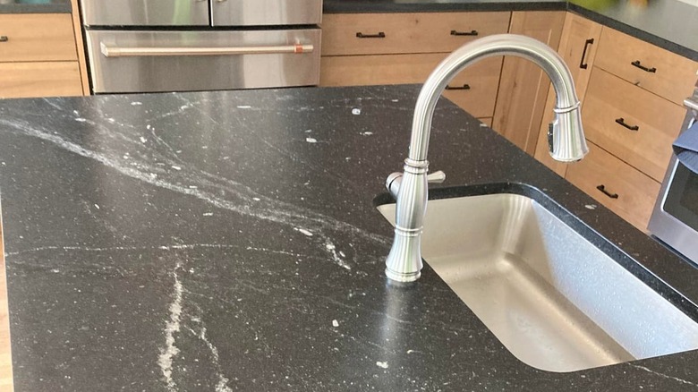 A close-up view of a black marble-like granite countertop in a kitchen