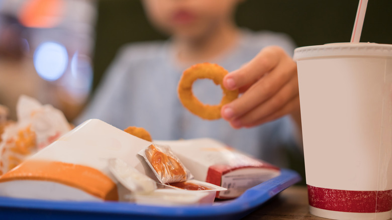 kid eating onion ring with fast food kids meal