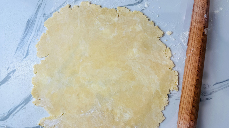 Rolled out dough next to rolling pin