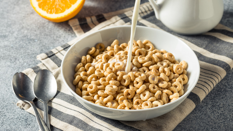 Pouring milk into bowl of Cheerios