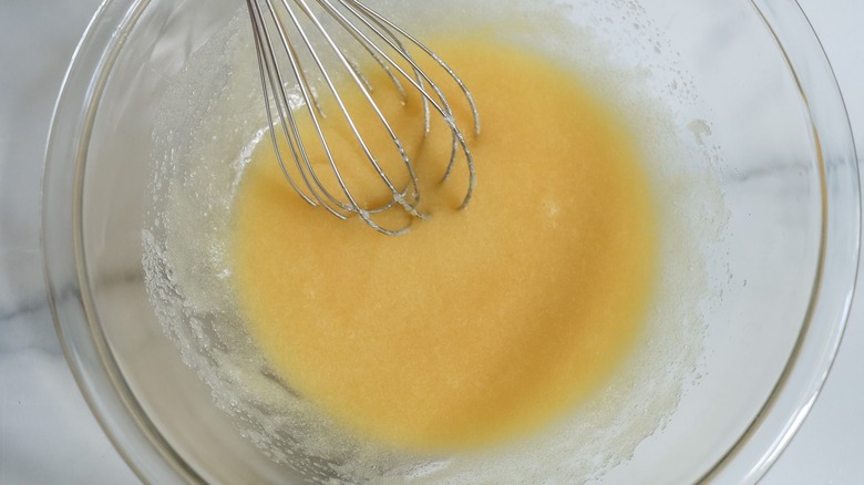 Egg, sugar, and butter mixture with whisk in bowl