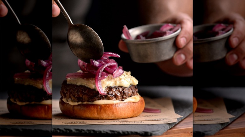 a Capital Burger being made with pickled onions