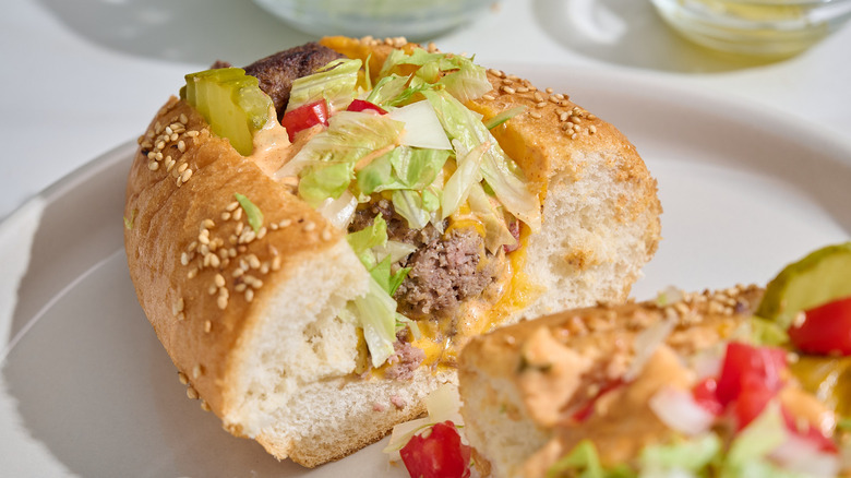 halved cheeseburger meatball sub on a table