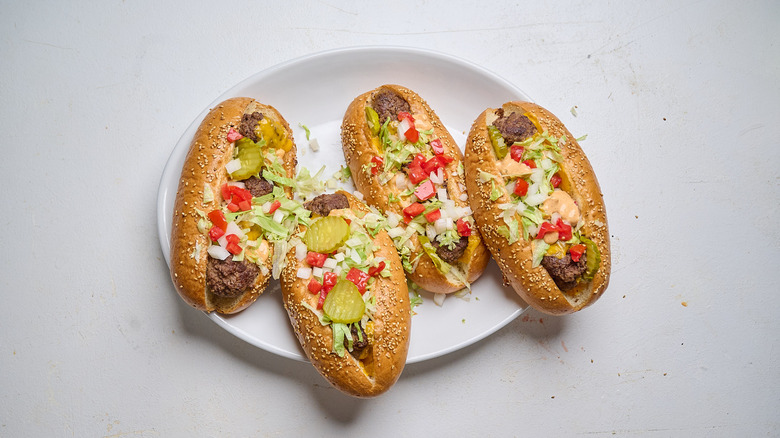 meatball subs topped with lettuce and tomato