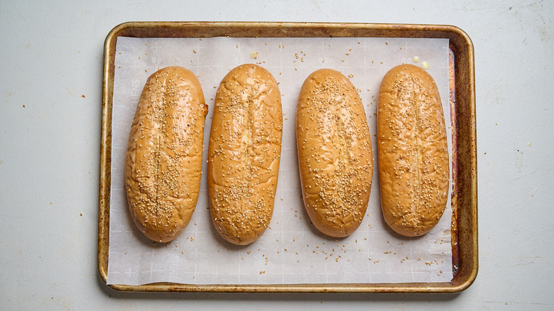 toasted hoagie rolls with sesame seeds on a sheet tray