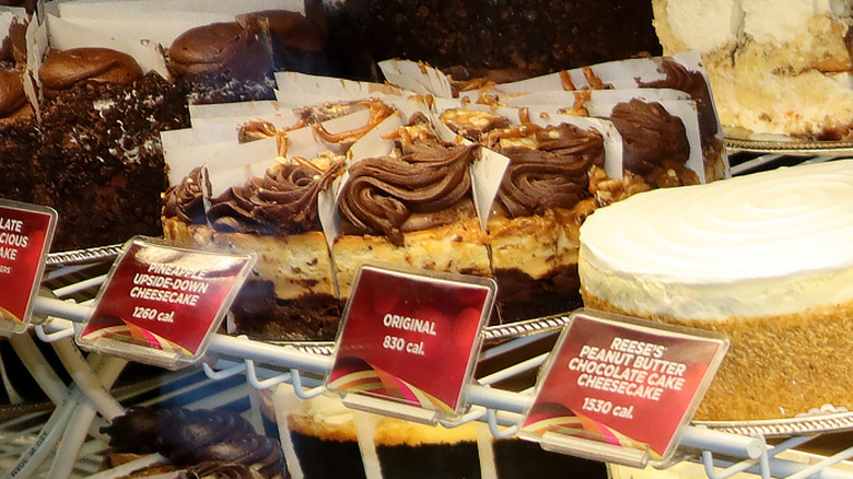 Whole and sliced cheesecakes on display at Cheesecake Factory restaurant