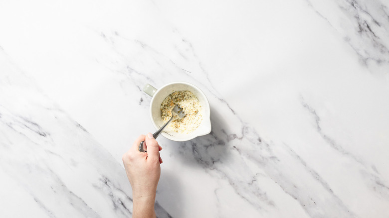 Mixing cheesy garlic topping
