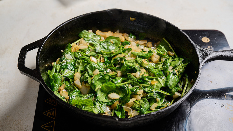 cooking garlic and spinach in a skillet