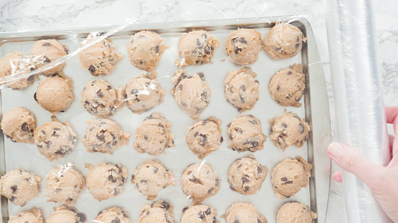A person prepares cookie dough for the freezer.