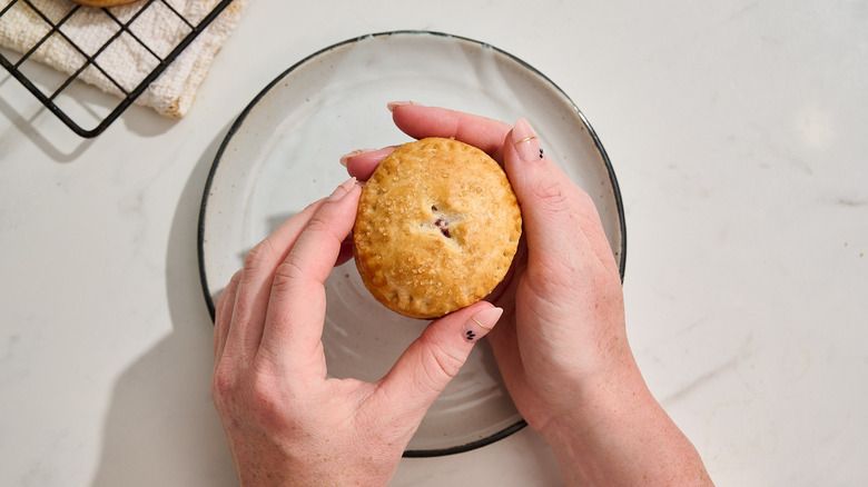 holding a cherry hand pie between two hands