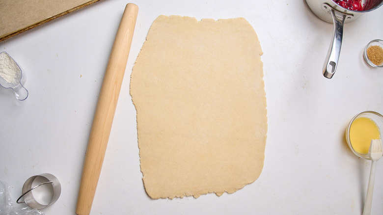 rolling the dough flat on a table