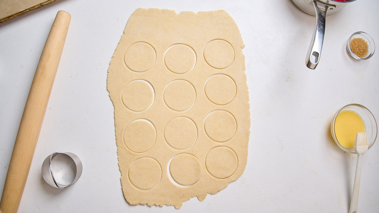 cutting circles out of the dough with a biscuit cutter