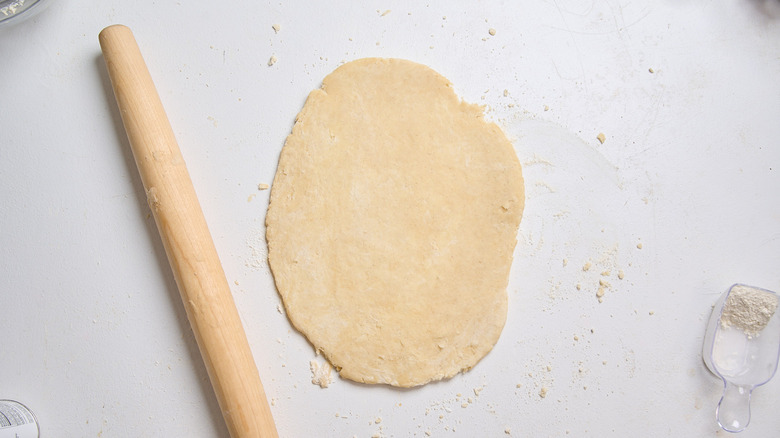 dough rolled out on a surface with a rolling pin