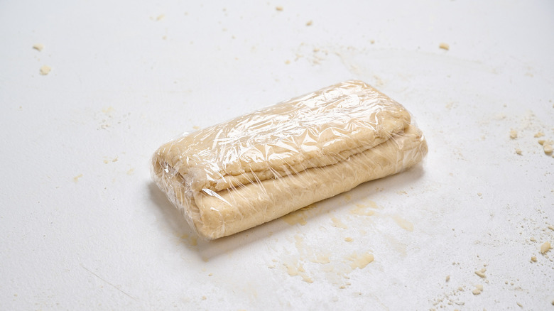 folded dough wrapped in plastic wrap