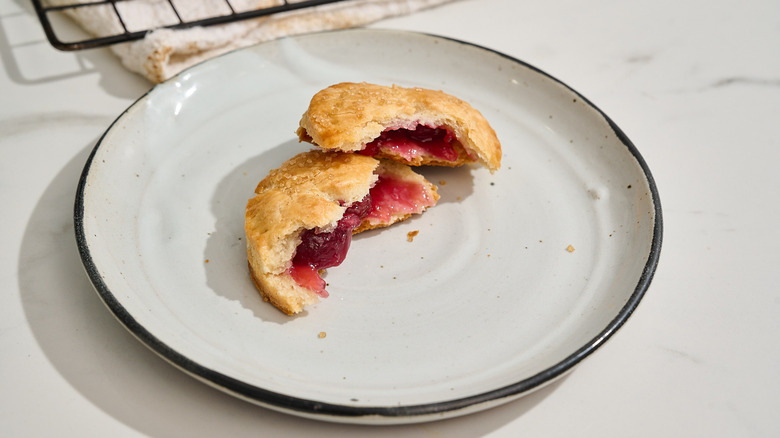 cherry hand pie split in half on a plate