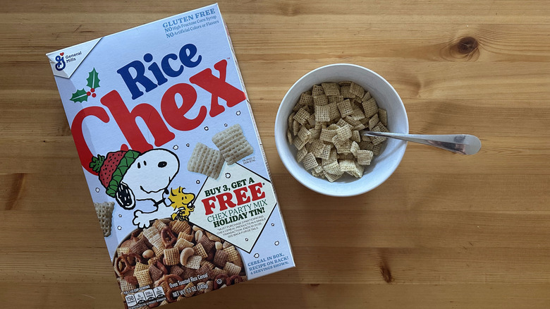 Rice Chex in white bowl next to a box on wooden table