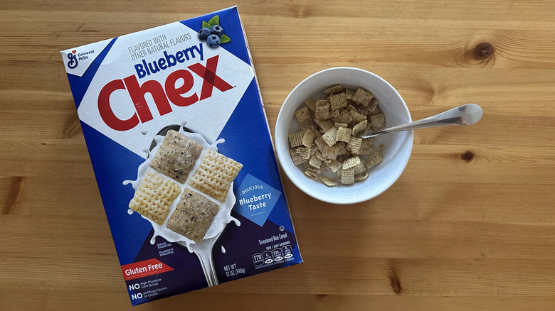 Blueberry Chex cereals in white bowl next to a box on wooden table