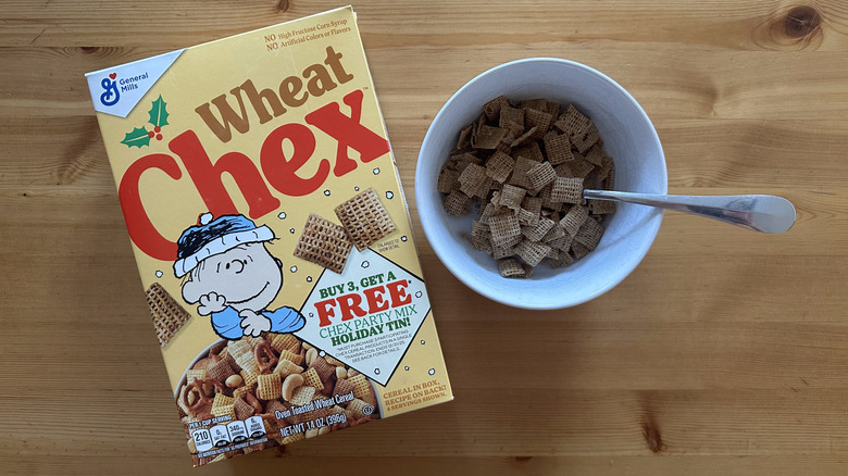 Wheat Chex in white bowl on wooden table next to a box