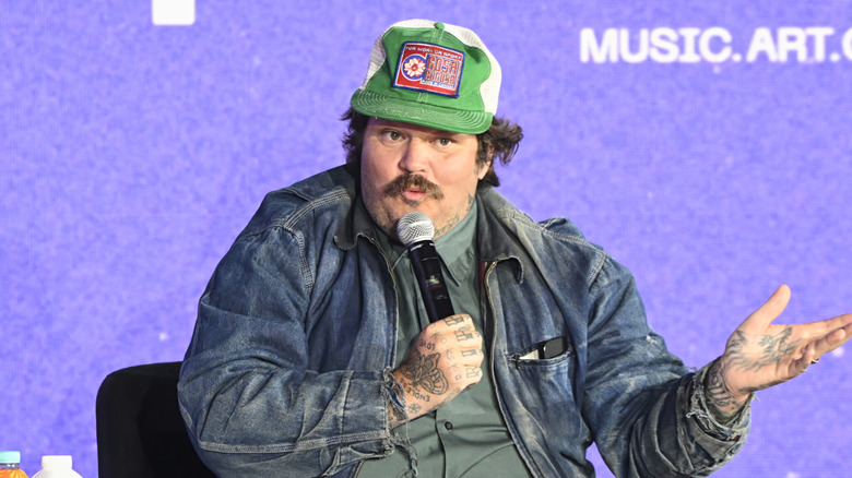 Chef Matt Matheson addresses an audience with a microphone in his hand