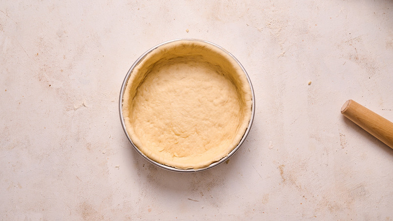 dough pressed into pizza pan