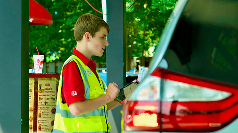 Chick-fil-A employee taking customer order outside car