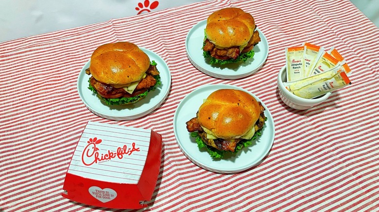 Three of Chick-fil-A's new sandwiches on plates over a striped tablecloth