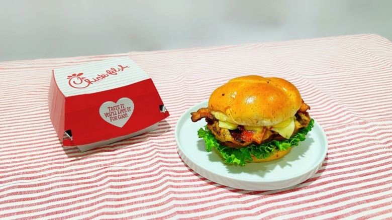 Chick-fil-A's new grilled jalapeño ranch club on a plate next to a takeout box