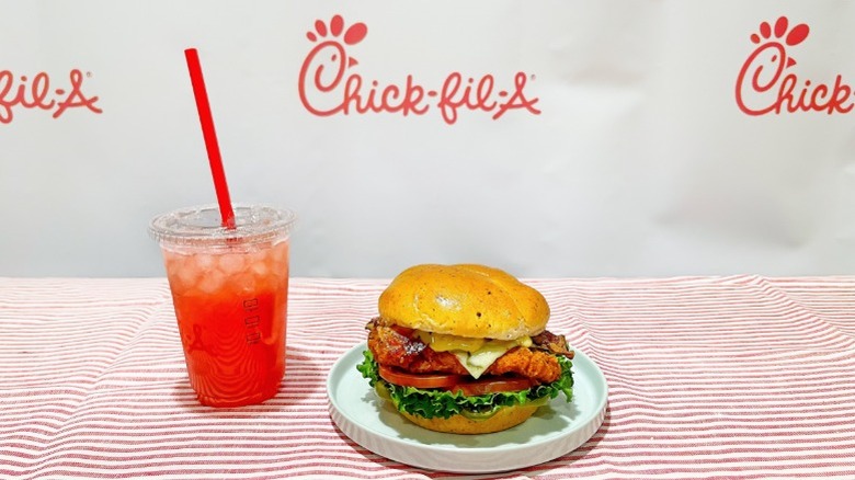 Chick-fil-A's new spicy jalapeño ranch club on a plate next to a strawberry hibiscus lemonade