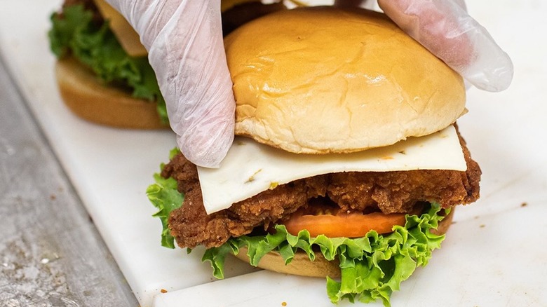 Closeup of Chick-fil-A worker assembling a spicy chicken sandwich
