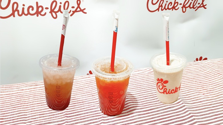 Three strawberry hibiscus drinks on top of a striped tablecloth