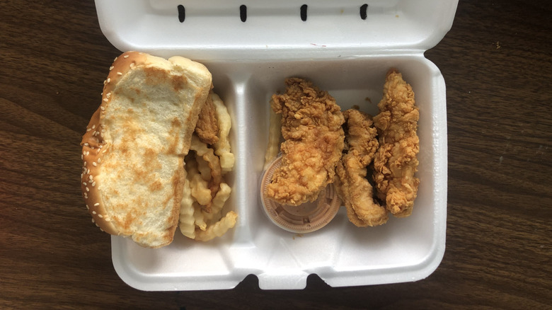 Chicken tenders, toast, and fries in a Styrofoam container.