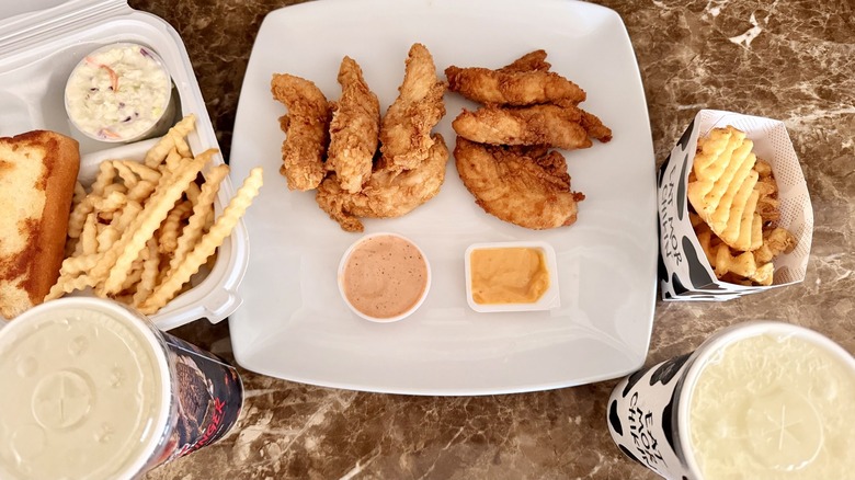 overhead shot of Raising Cane's and Chick-fil-A's chicken tenders meals