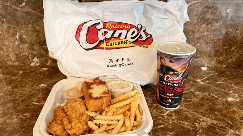 Raising Cane's The Box Combo Meal showing the chicken tenders, crinkle-cut fries, coleslaw, Texas toast, Cane's sauce, and soda