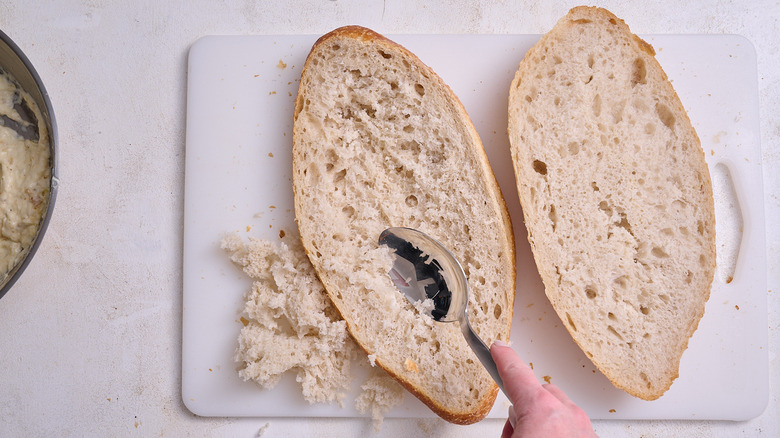 scooping bread out of crust