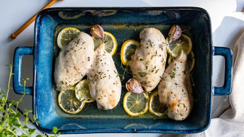 Simple Baked Chicken Breast in blue baking dish with lemon