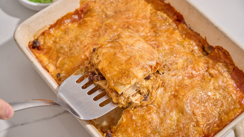 serving slice of enchilada casserole from dish