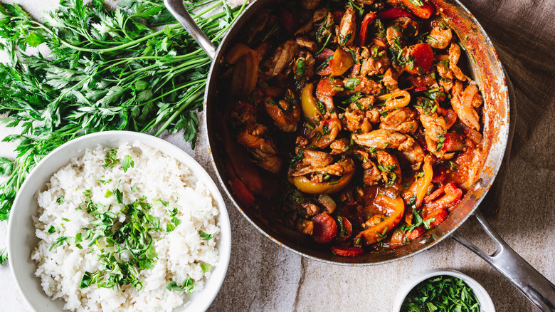 chicken in saucepan with rice and herbs