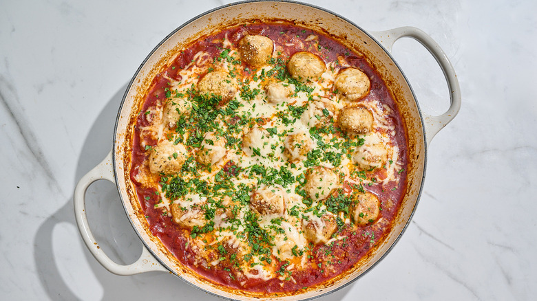 chicken parmesan meatballs in a skillet with tomato sauce