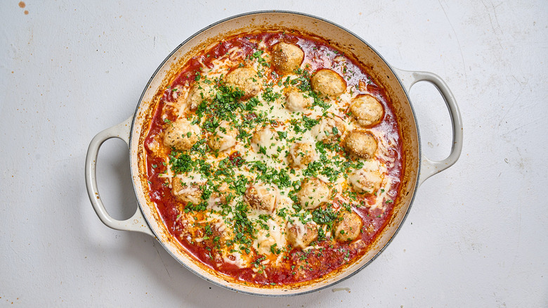 serving meatballs in a skillet topped with parsley
