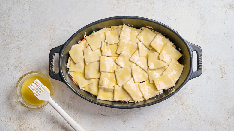 brushing egg wash across puff pastry