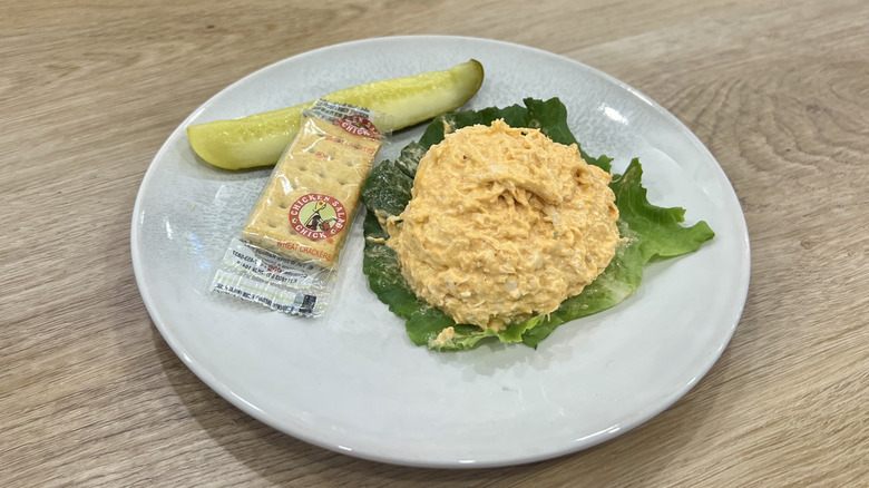 Chicken Salad Chick Buffalo Barclay scoop on a plate with crackers and a pickle